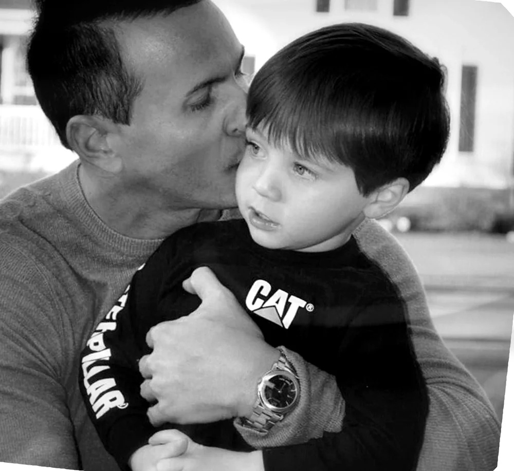 Michael, the designer and developer of Chip In, holding his young son.